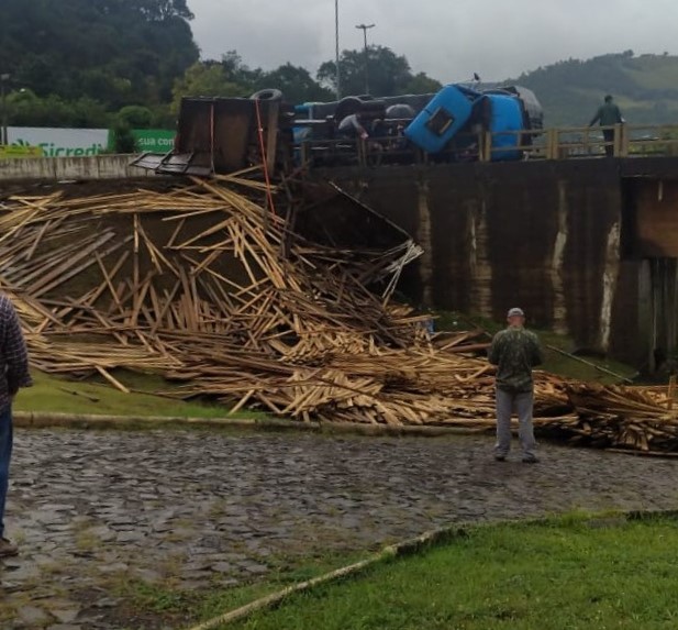 Caminhão carregado com madeira tomba na ponte do Goio-Ên e deixa duas pessoas feridas